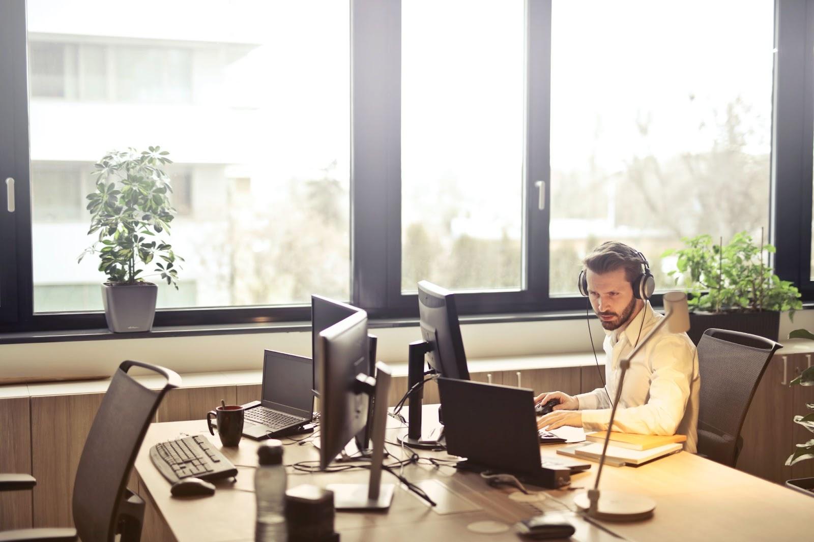 man working at a computer, wearing headphone
